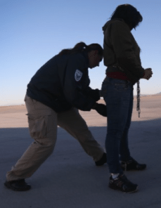 ICE agent secures a woman in irons